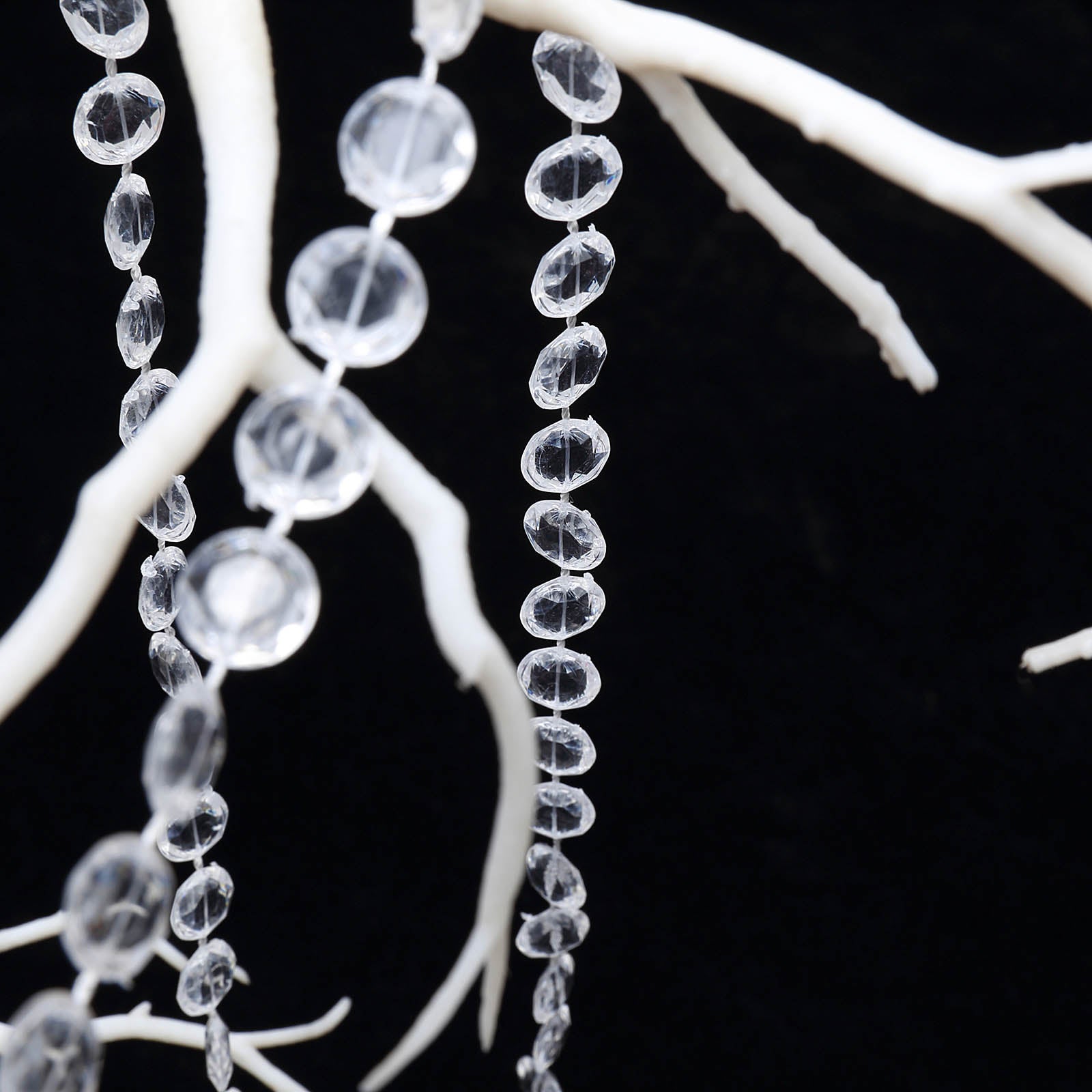Clear acrylic crystal diamond garland chain bead roll on a decorative branch.