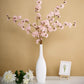 Blush artificial silk carnation flower stems in a white vase.