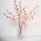 Blush artificial silk carnation flower stems in a clear vase.