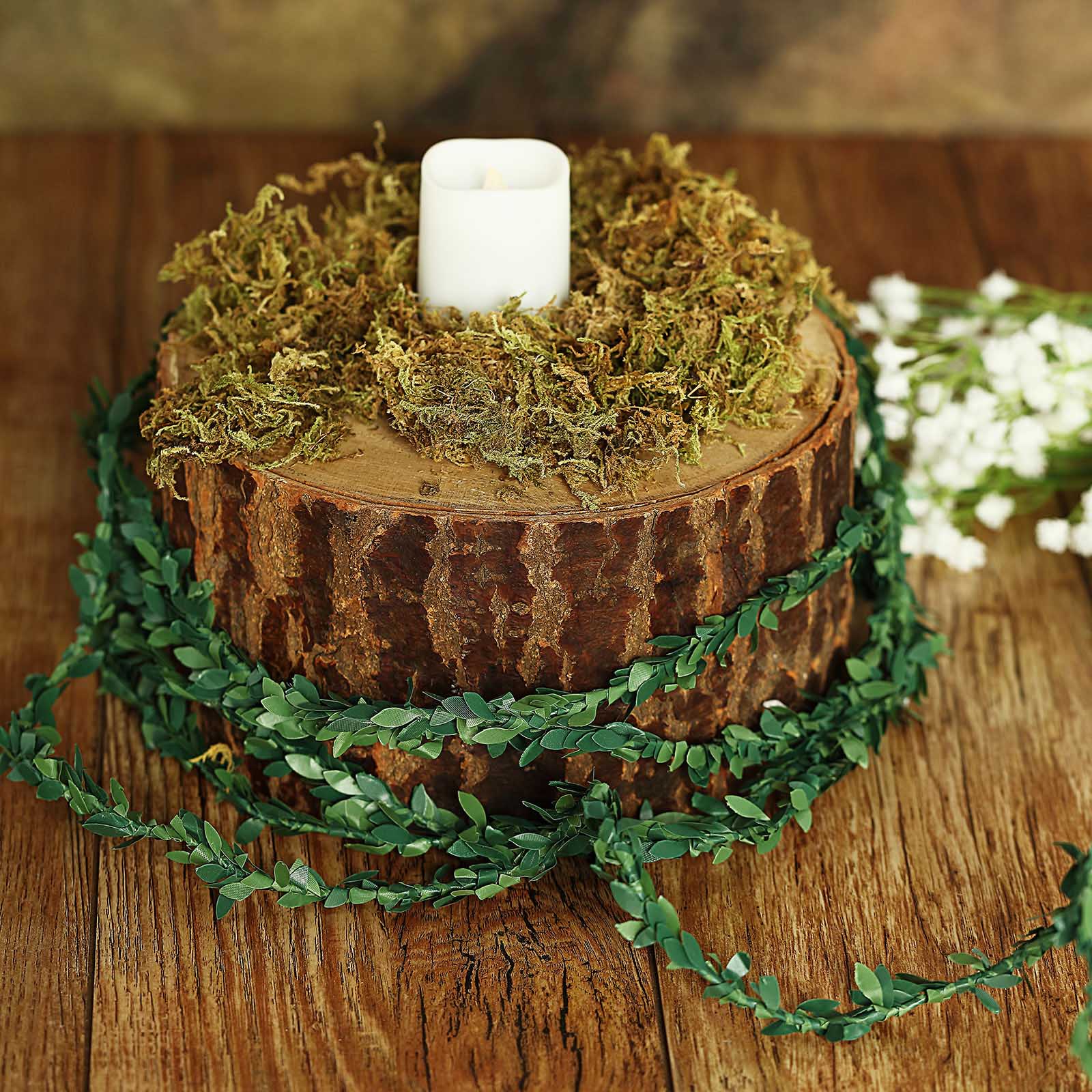 Mini green artificial leaf garland wrapped around a rustic wooden centerpiece.