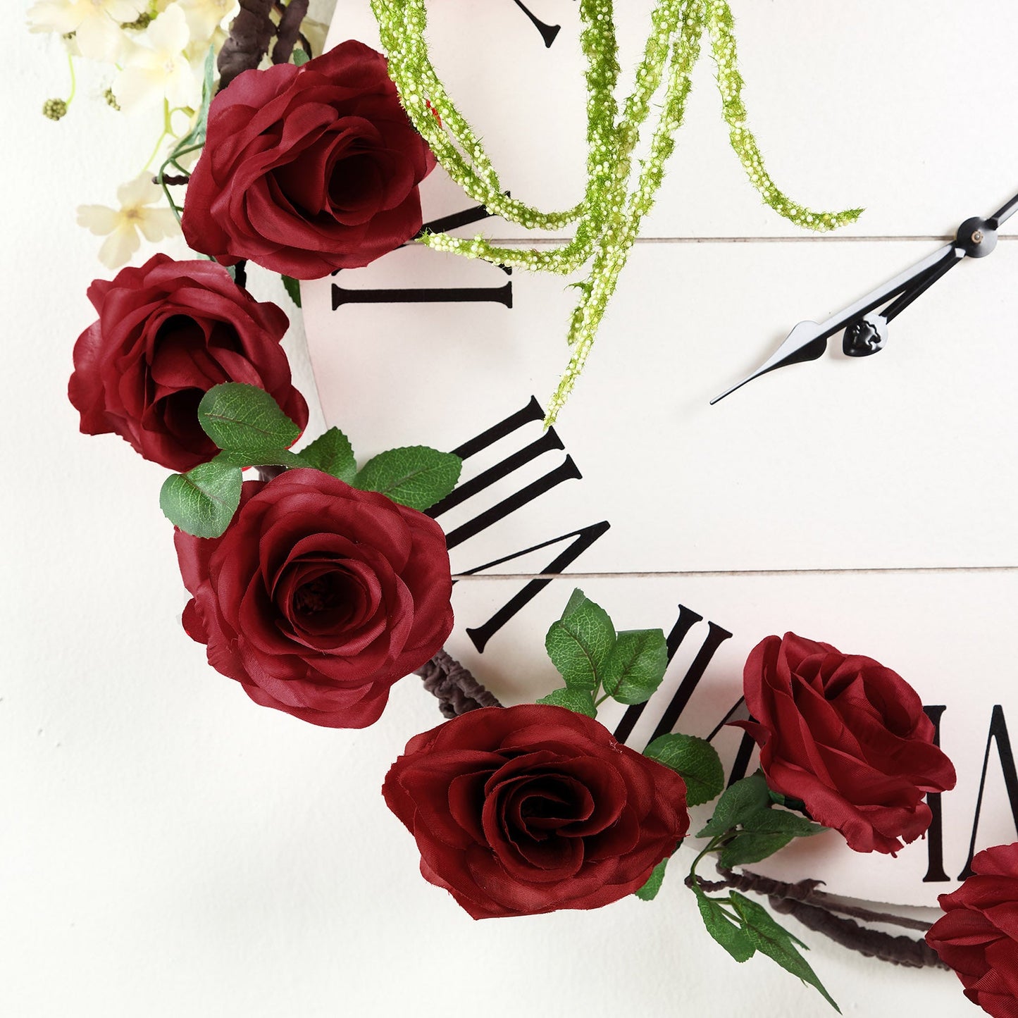 Burgundy artificial silk rose garland with green faux vine accents.