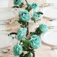 Aqua artificial silk rose hanging flower garland vine on a table setting.