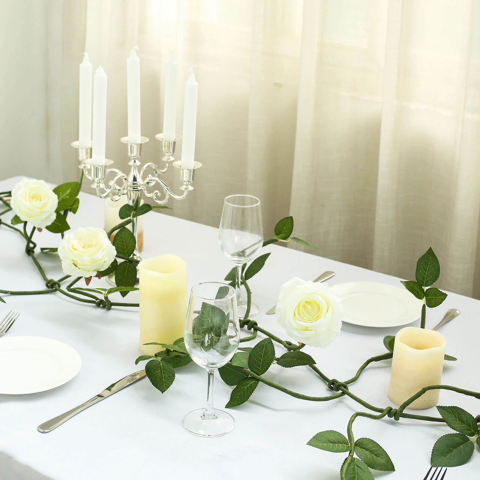 Cream artificial rose and leaf flower garland vine decoration for table.