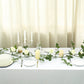 Cream artificial rose and leaf flower garland vine on a dining table.