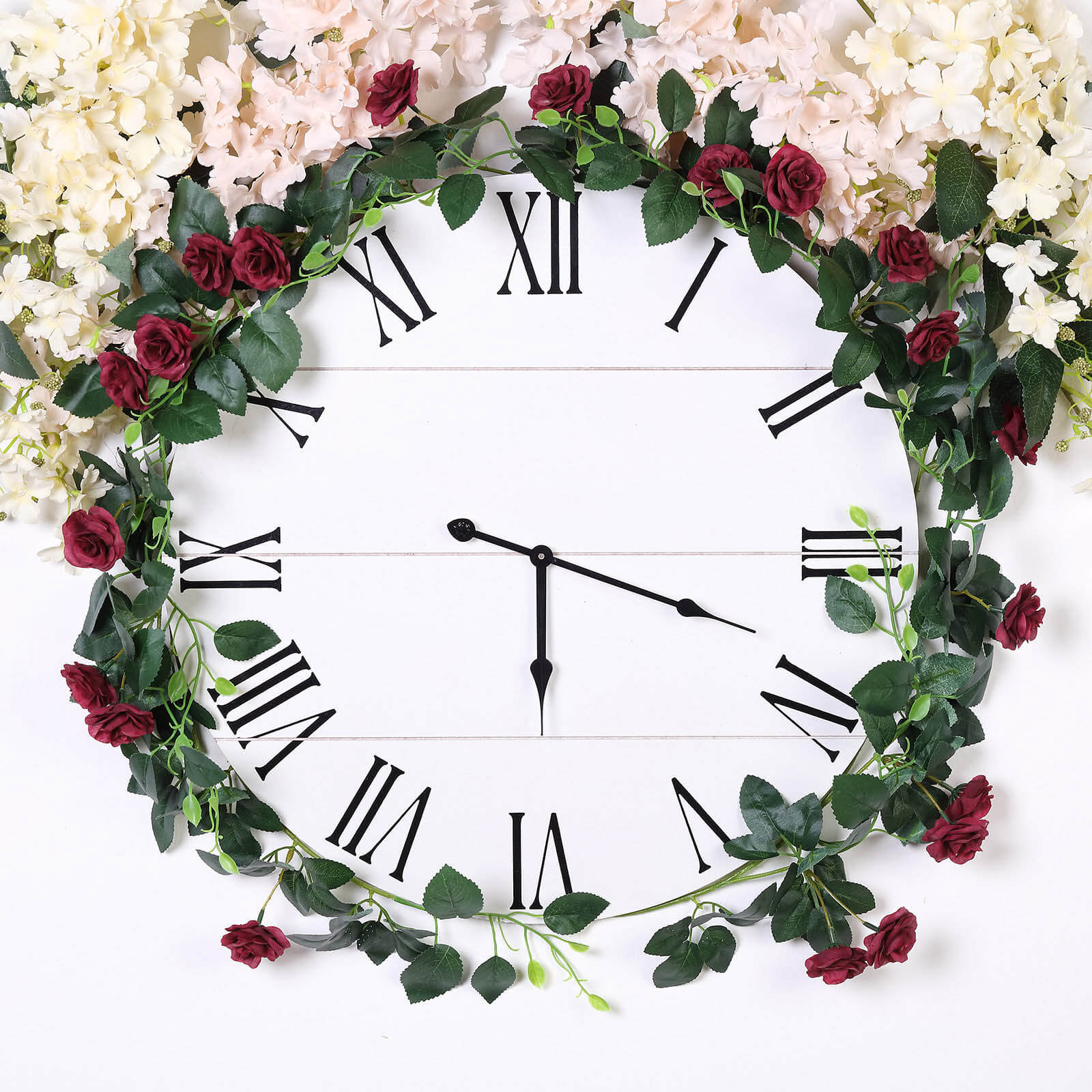 Burgundy artificial silk roses flower garland on a clock backdrop.
