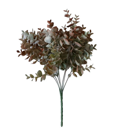 Frosted green and red artificial eucalyptus plant stems in a bouquet.