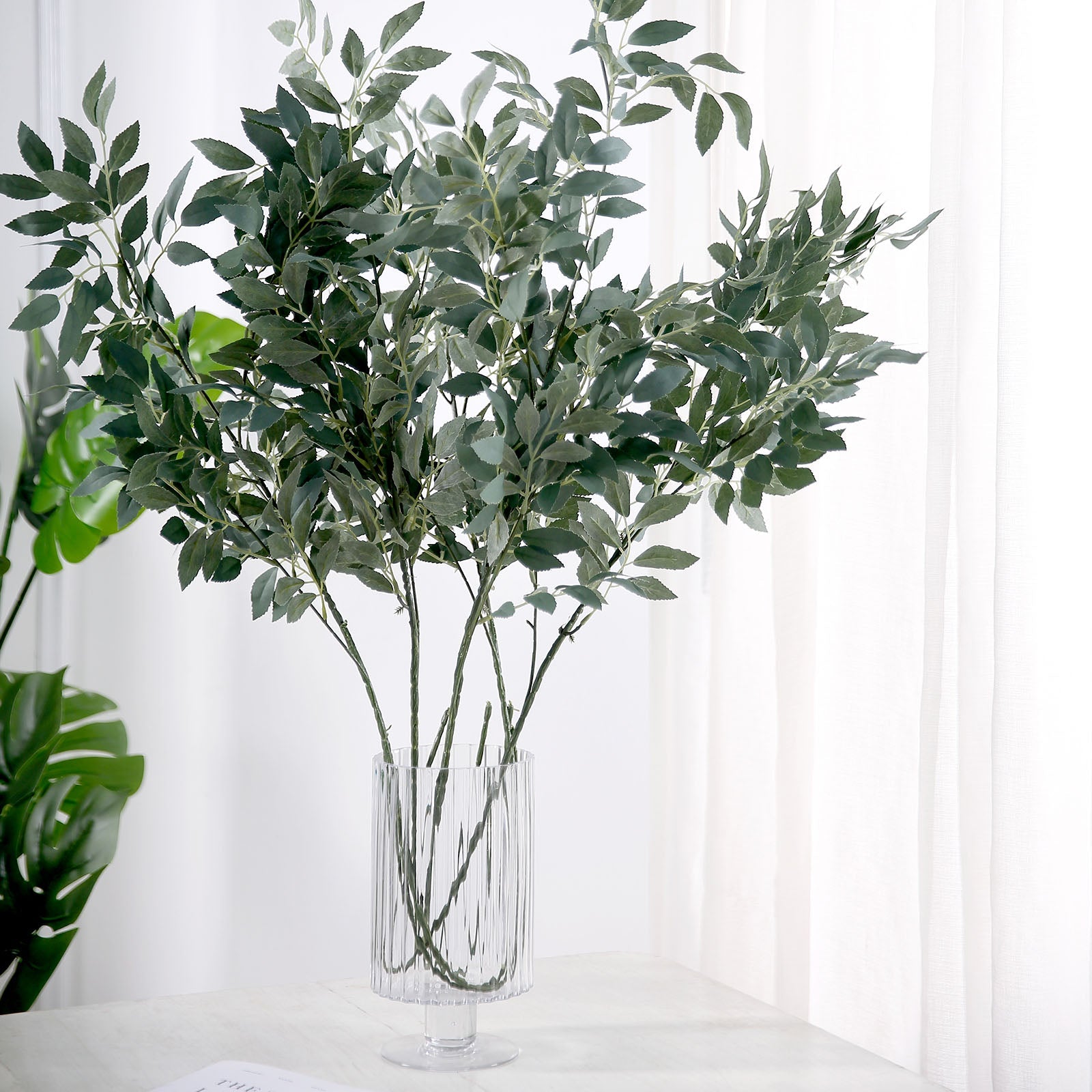 Frosted green artificial silk beech leaf branches in a vase.