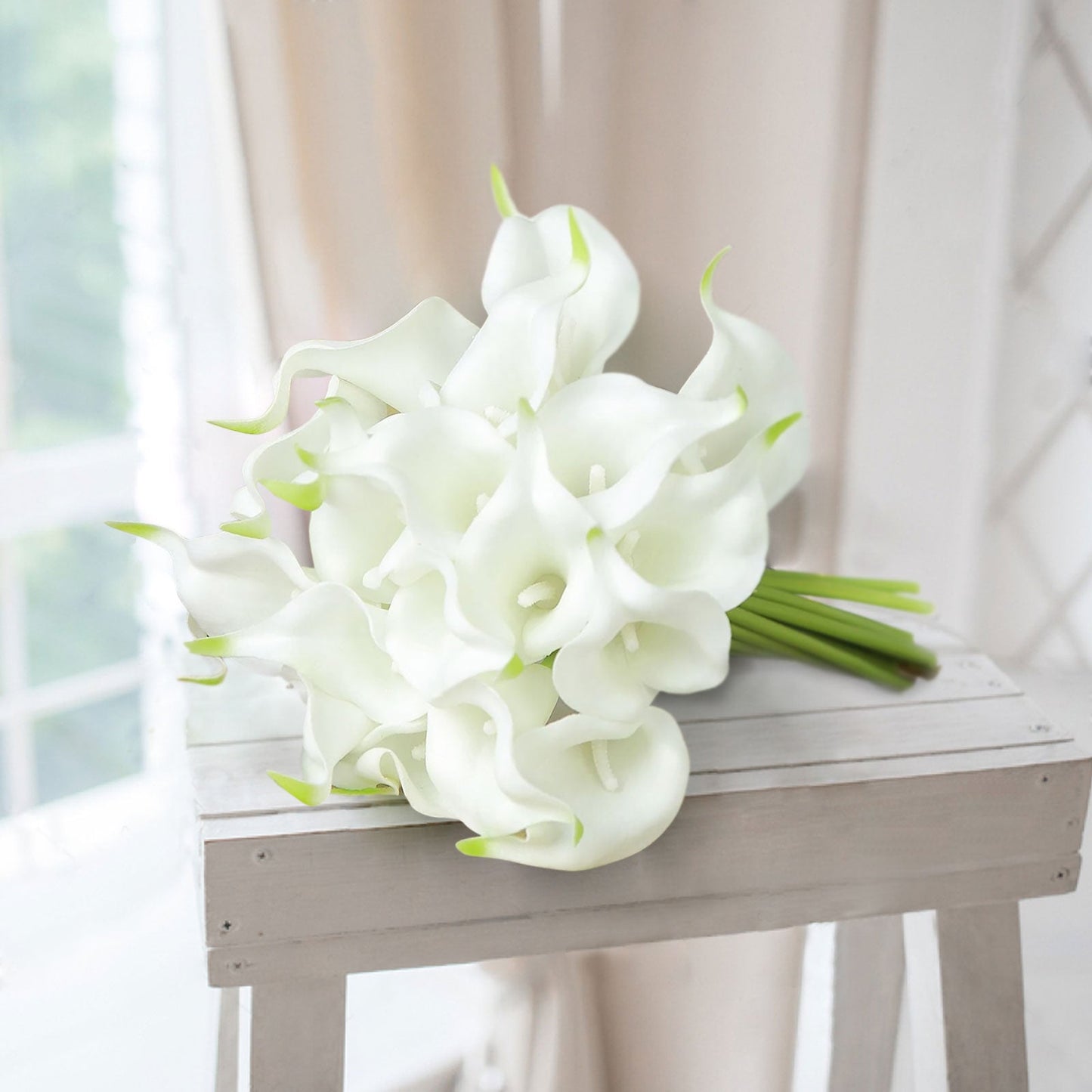 White artificial calla lily flowers with green accents.