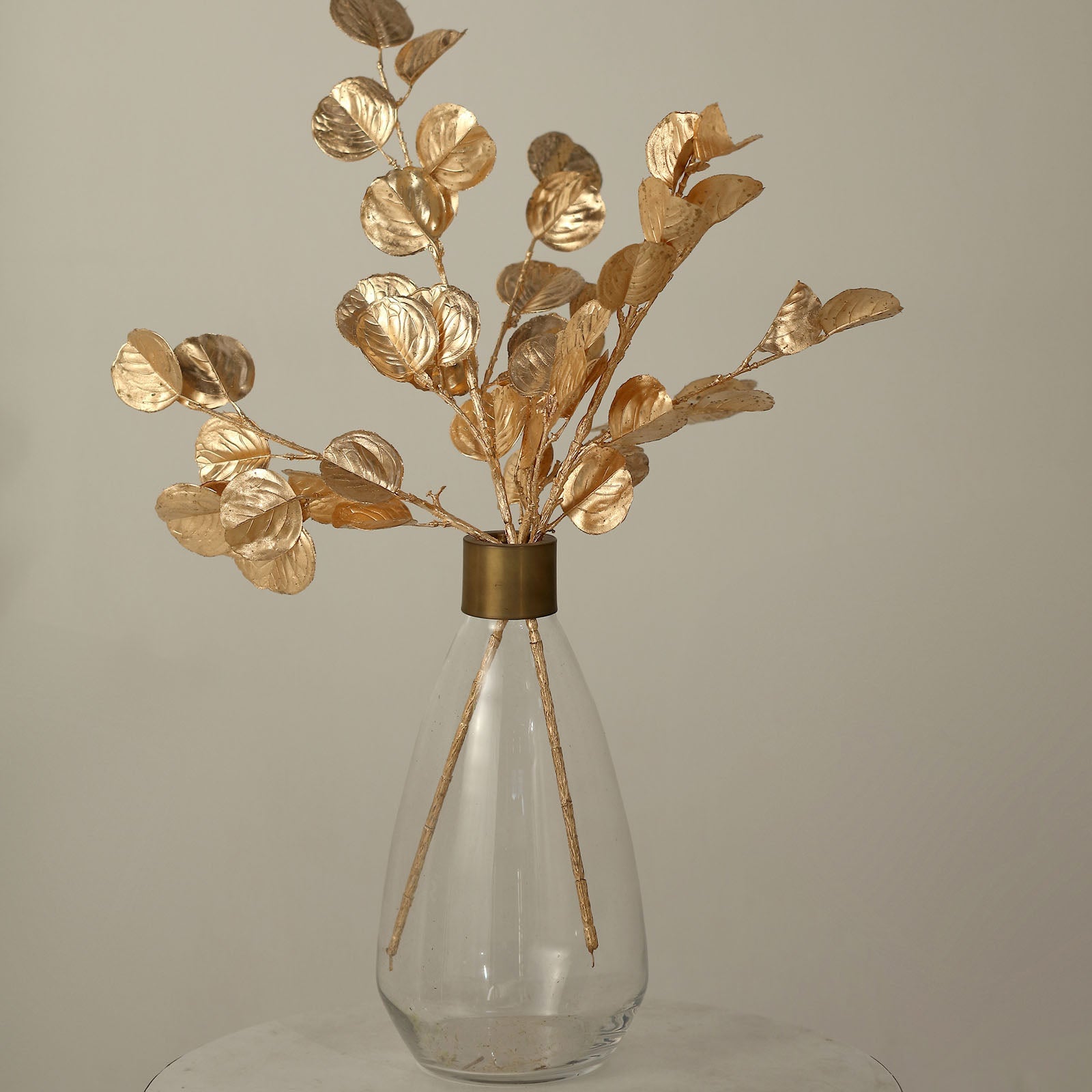 27" Metallic Gold Artificial Eucalyptus Leaf Branches in a clear vase.