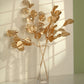 27" Metallic Gold Eucalyptus Leaf Branches in a clear vase.