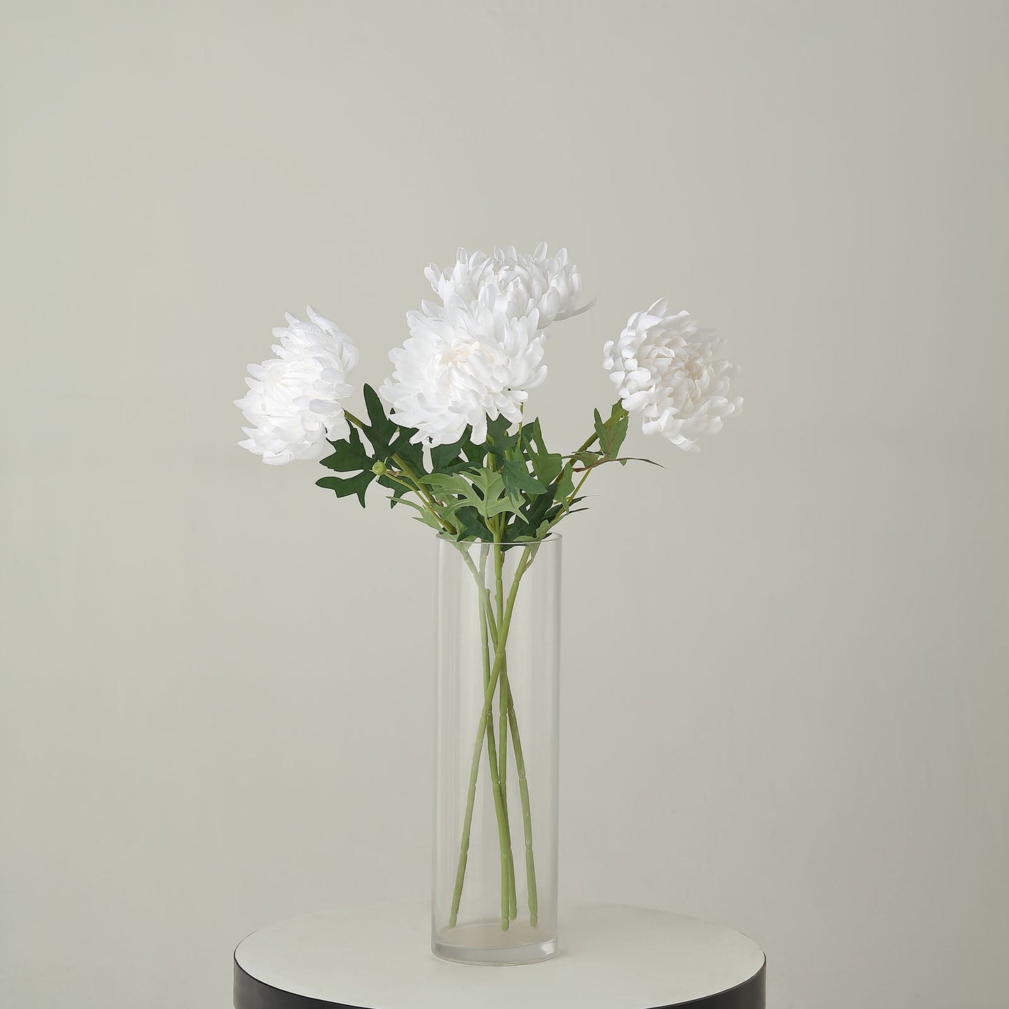White artificial silk chrysanthemum bouquet in a glass vase.