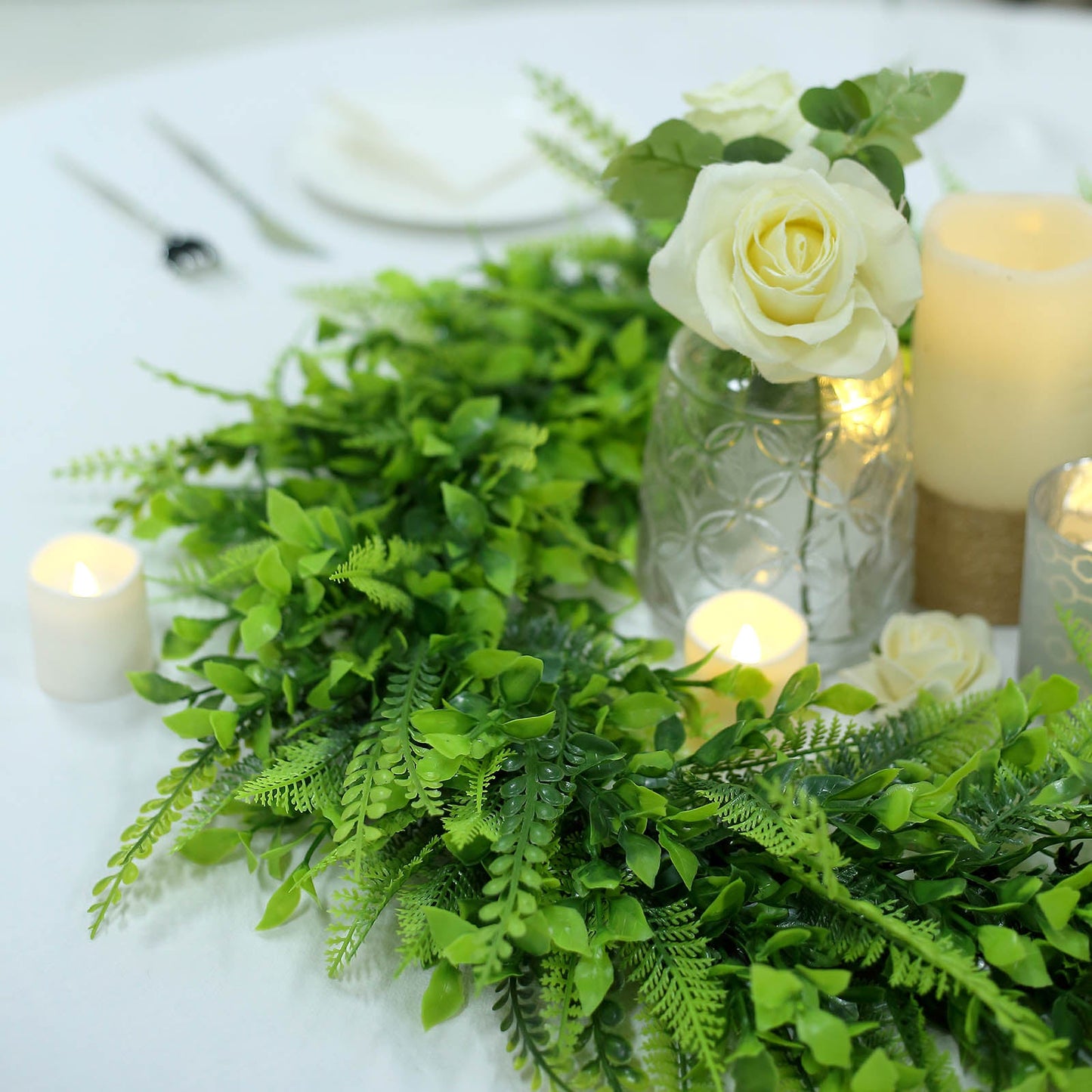 22" Green Artificial Boxwood Fern Mix Spring Wreaths on a table with candles and flowers.
