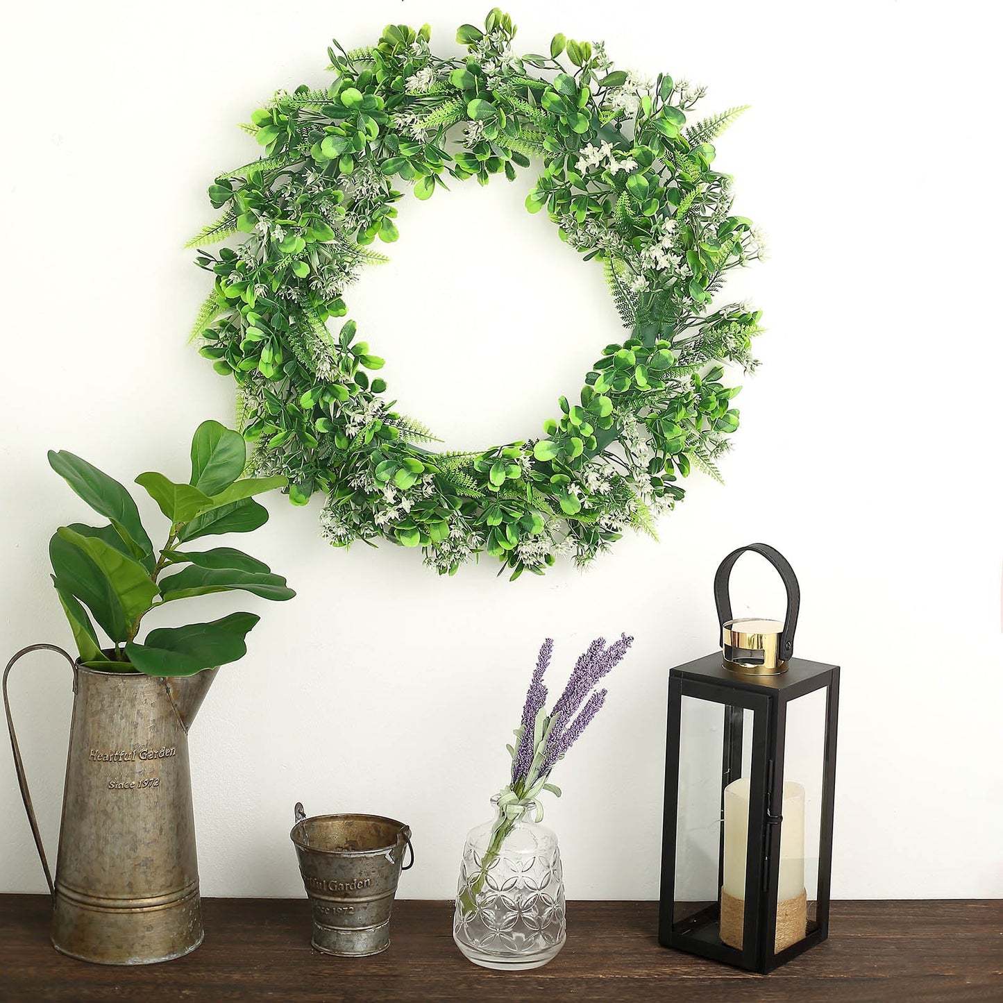 22" Green Artificial Boxwood Fern Mix Spring Wreath on a wooden table.