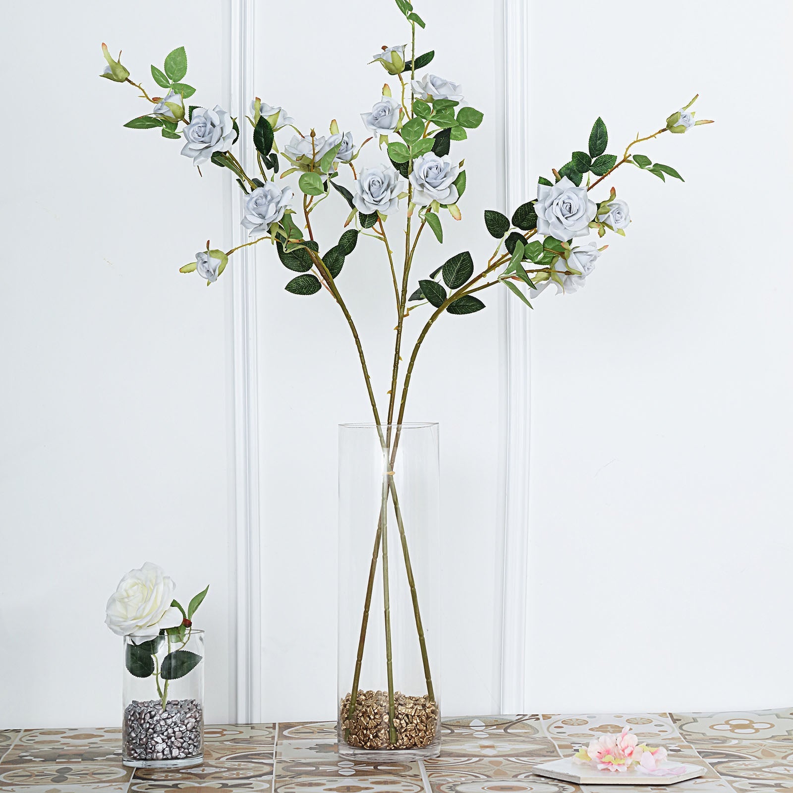Silver artificial silk rose flower bouquet in a clear vase.