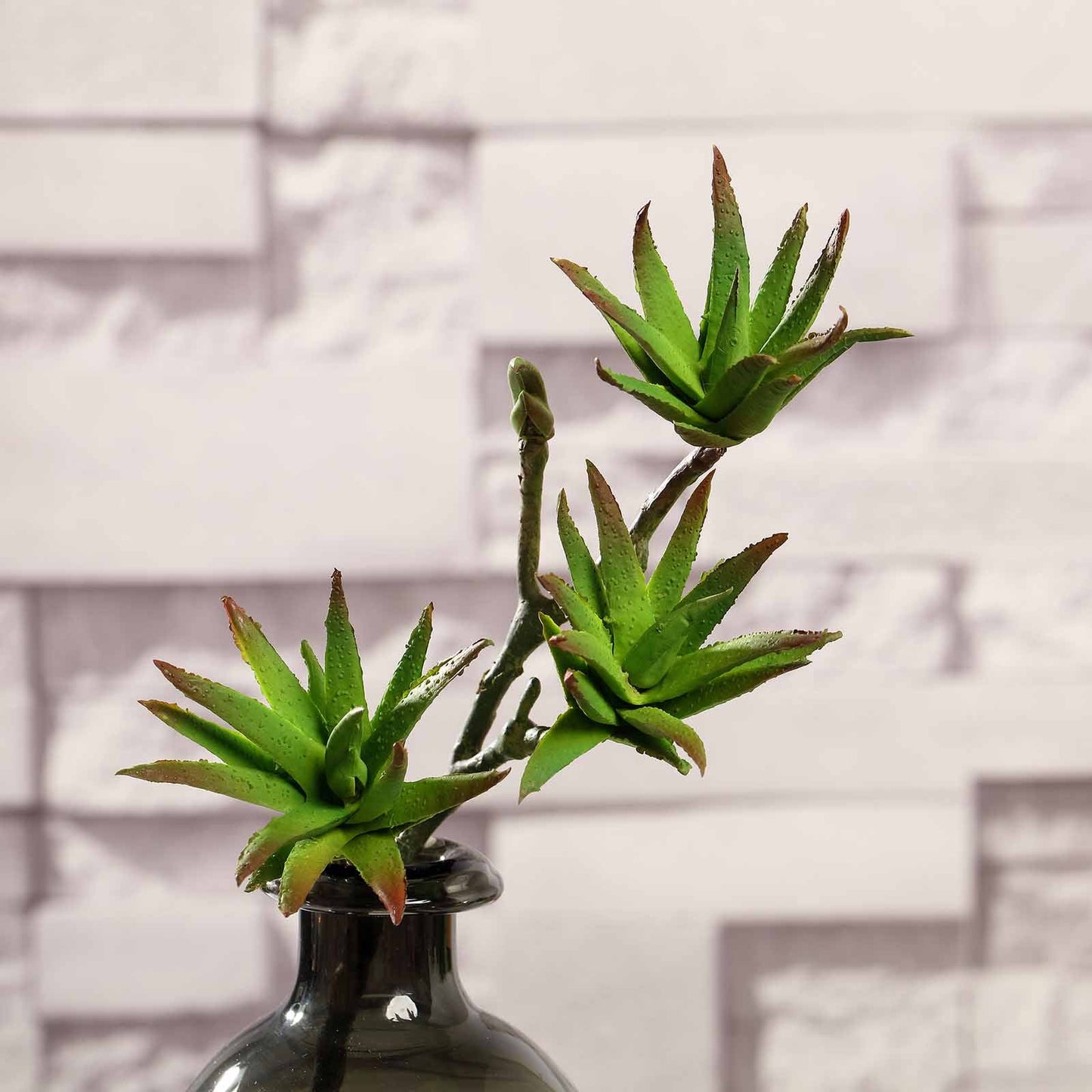 Green artificial yucca aloe vera succulent air plants in a vase.