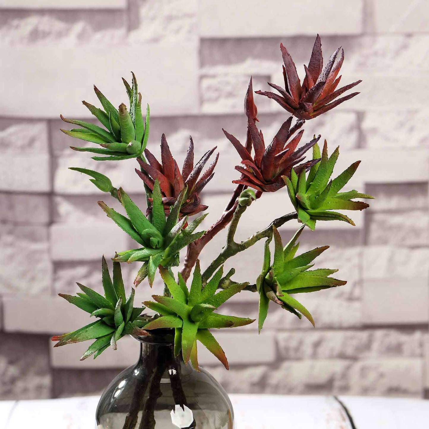 Assorted artificial yucca and aloe vera plants in green and red.