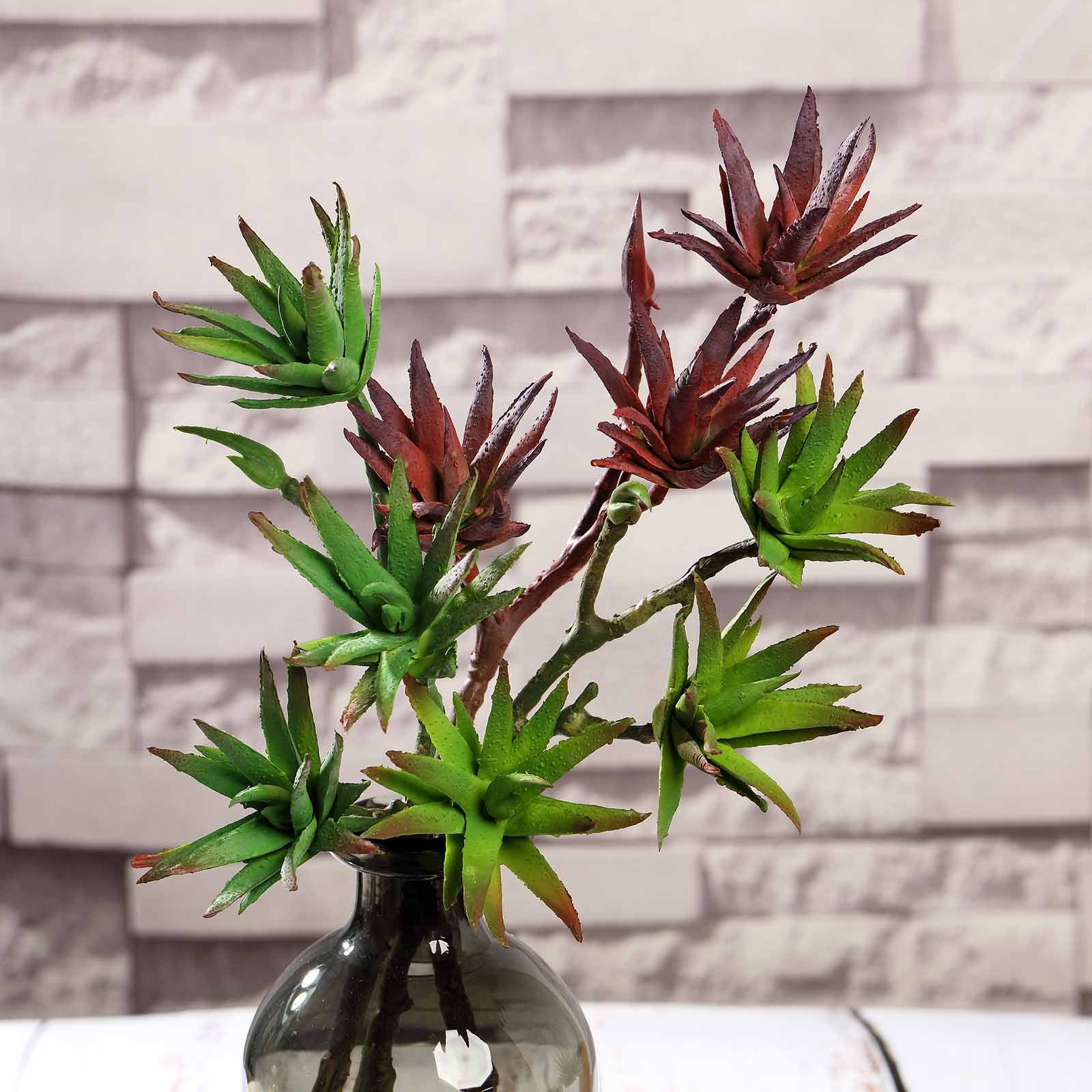 Assorted artificial yucca and aloe vera plants in green and red.