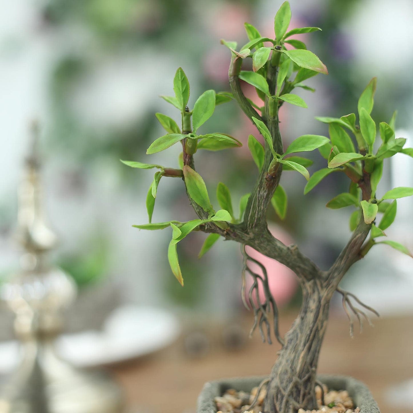 Green artificial willow tree in a concrete planter pot.