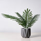 Assorted green artificial silk tropical palm leaf plants in a decorative pot.