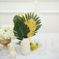 Green and gold artificial palm leaves in a decorative arrangement.