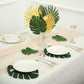 Green and gold artificial palm leaves in a tropical table setting.