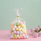 Clear gift bags with pastel candy treats and gold twist ties.