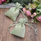 Sage green satin drawstring gift bags for wedding favors.