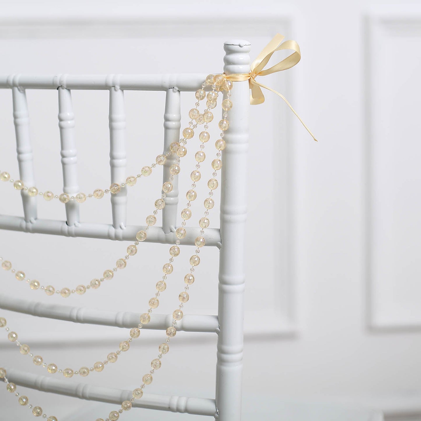 Amber faux pearl beaded chair back garland with ribbon decor.