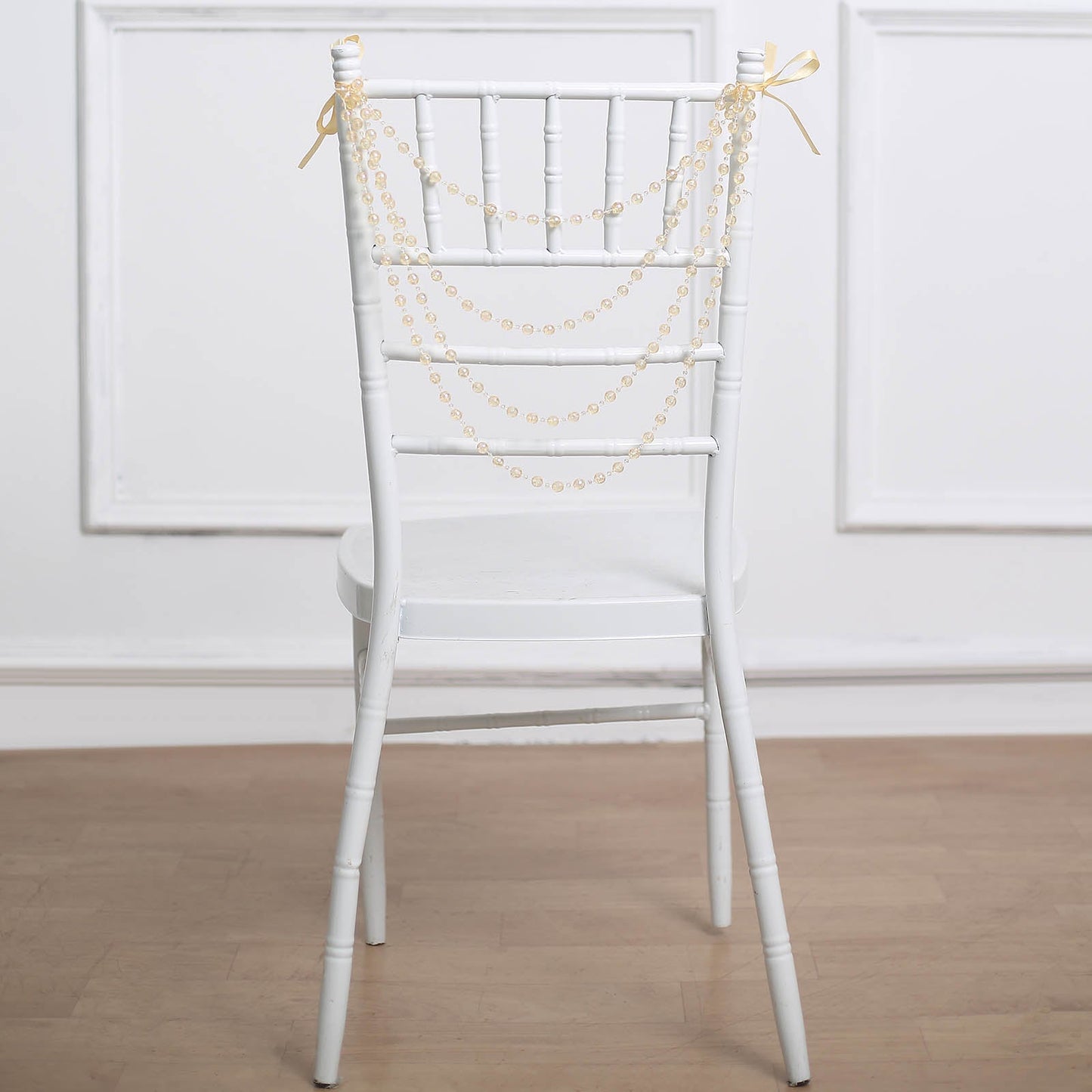Amber pearl beaded garland on a white Chiavari chair.