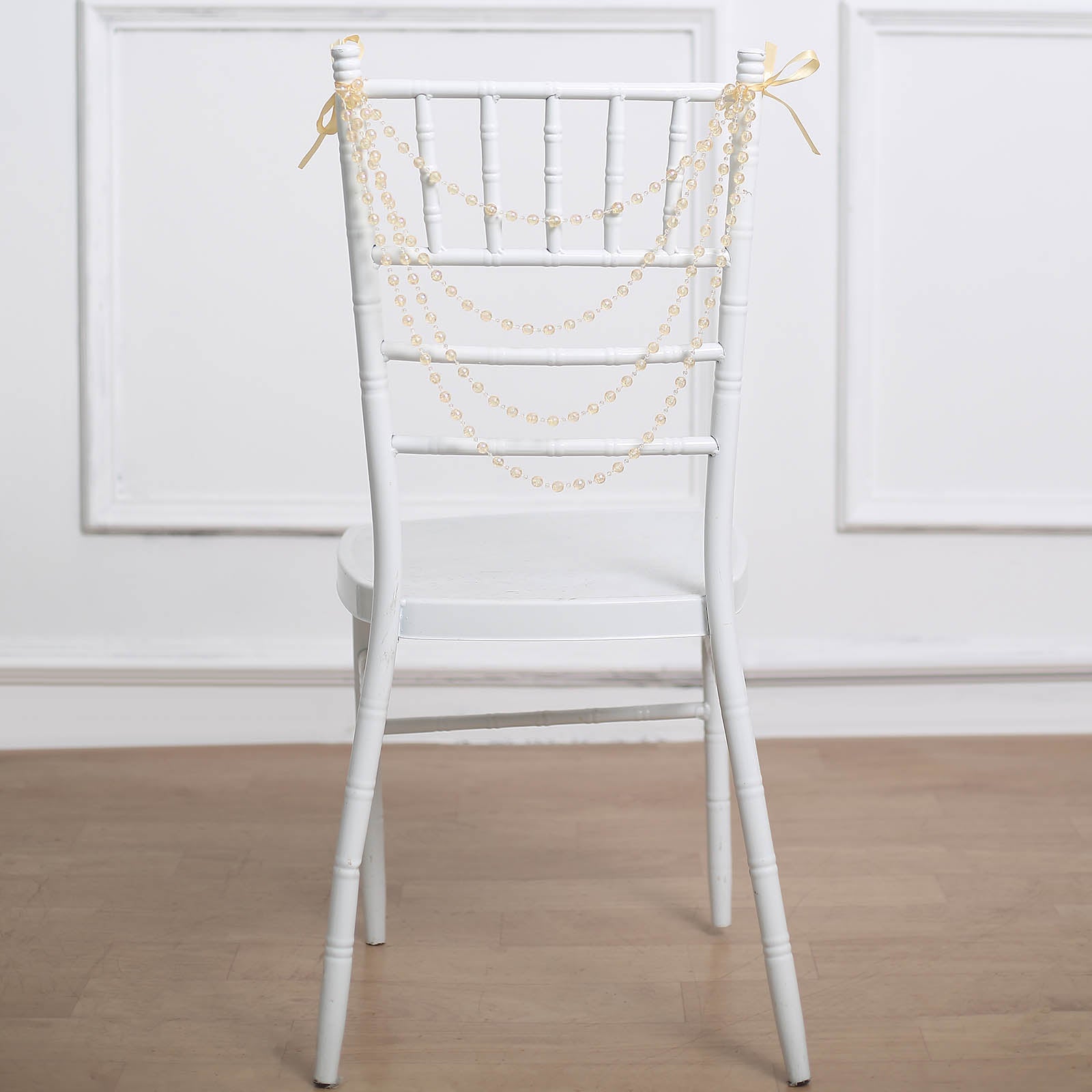 Amber pearl beaded garland on a white Chiavari chair.