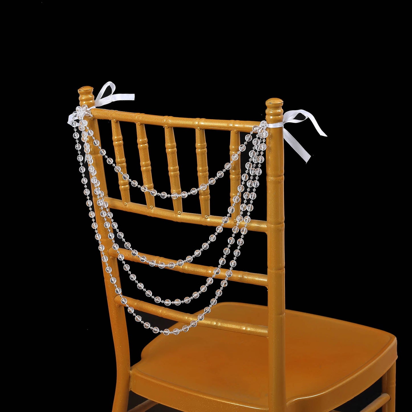 Clear faux pearl beaded garland on a gold Chiavari chair.