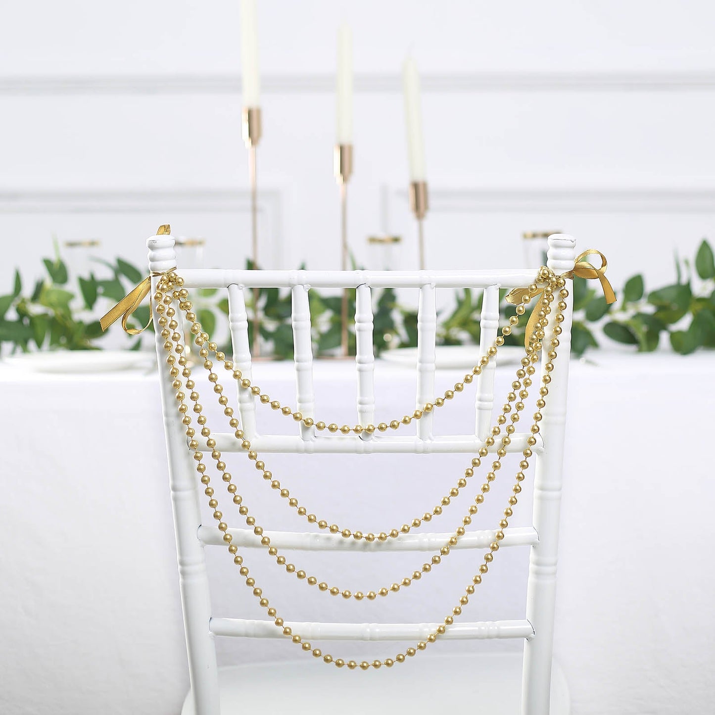 Gold faux pearl beaded garland for wedding chair decor.