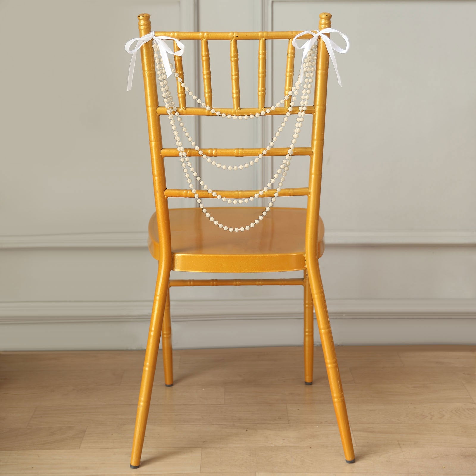Ivory pearl beaded wedding chair back garland with bows.