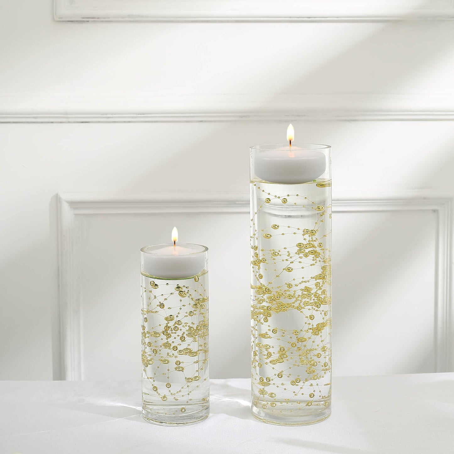 Gold vase filler with floating candles for elegant table decor.