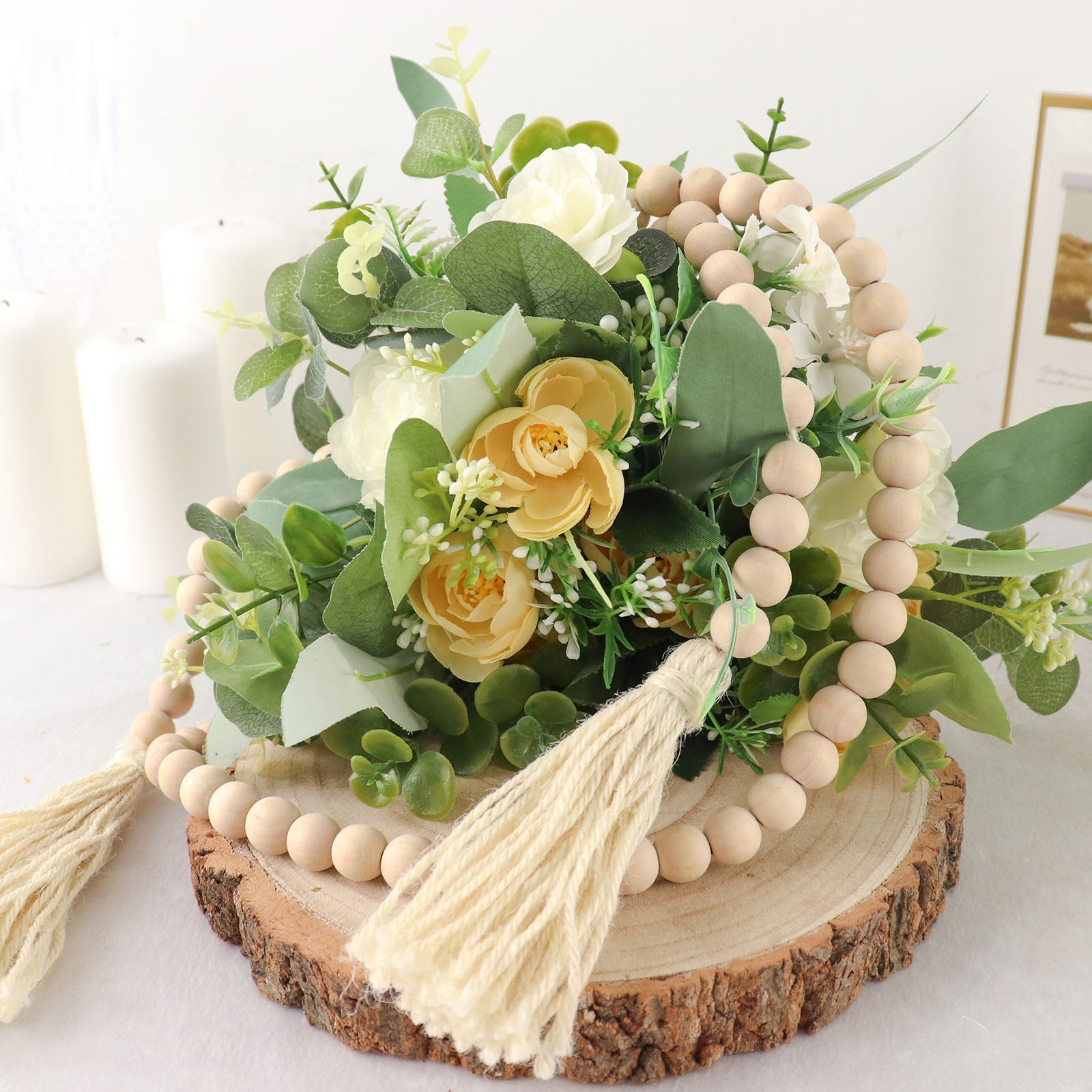 Cream rustic boho chic wood bead garland with tassels on a decorative display.