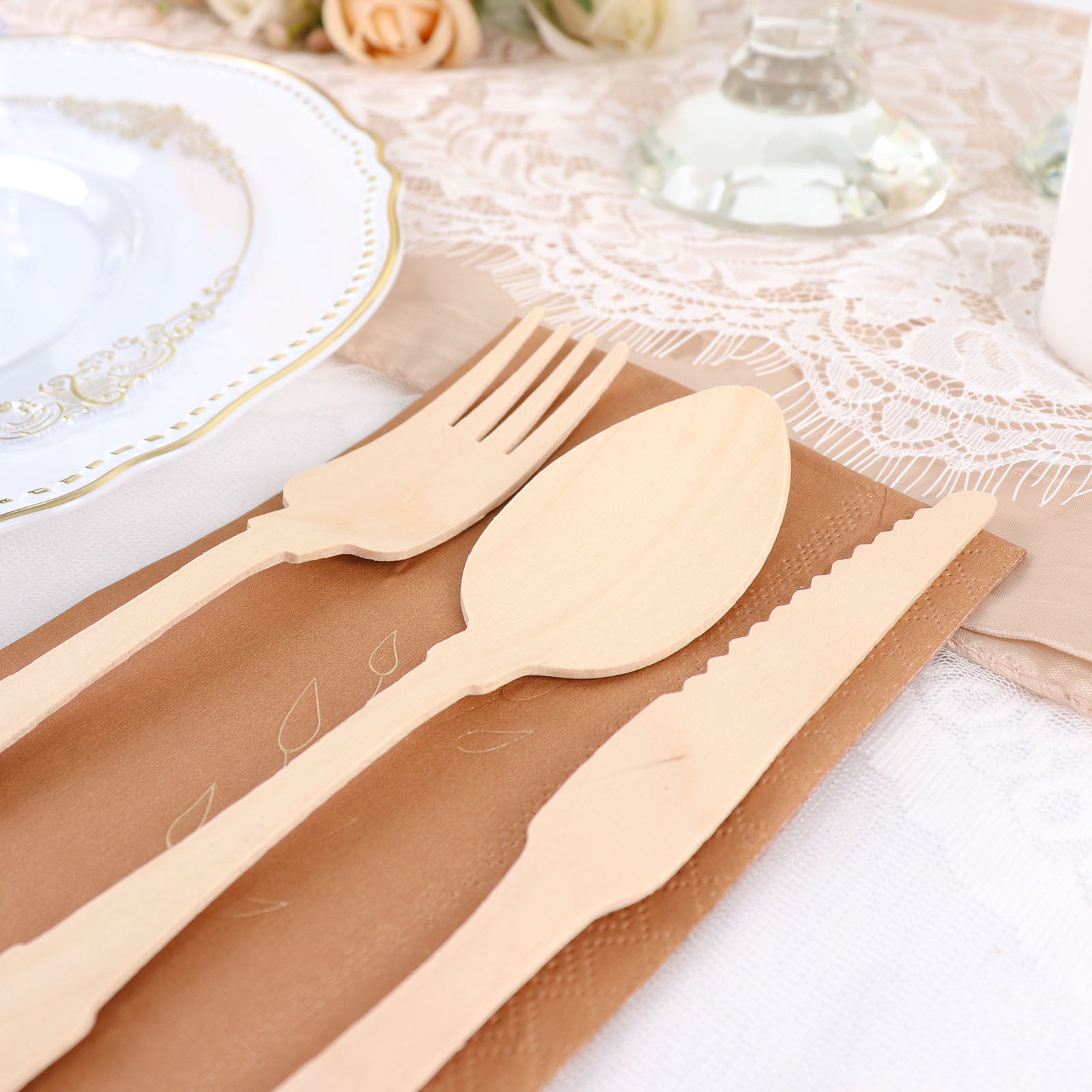 Eco-friendly vintage baroque design wooden utensil set on a beige table setting.