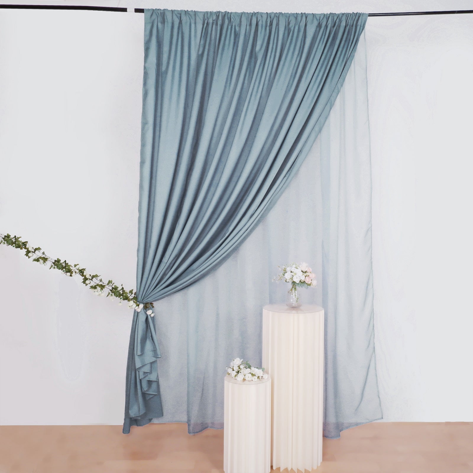 Dusty blue chiffon polyester event curtain drapes hanging elegantly.