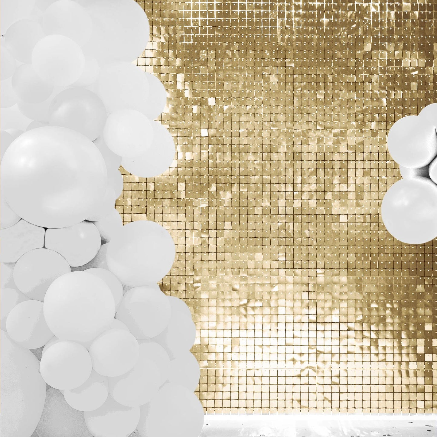 Ritzy gold sequin wall backdrop with white balloon decorations.