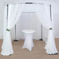Black metal wedding arch with white drapes for events.