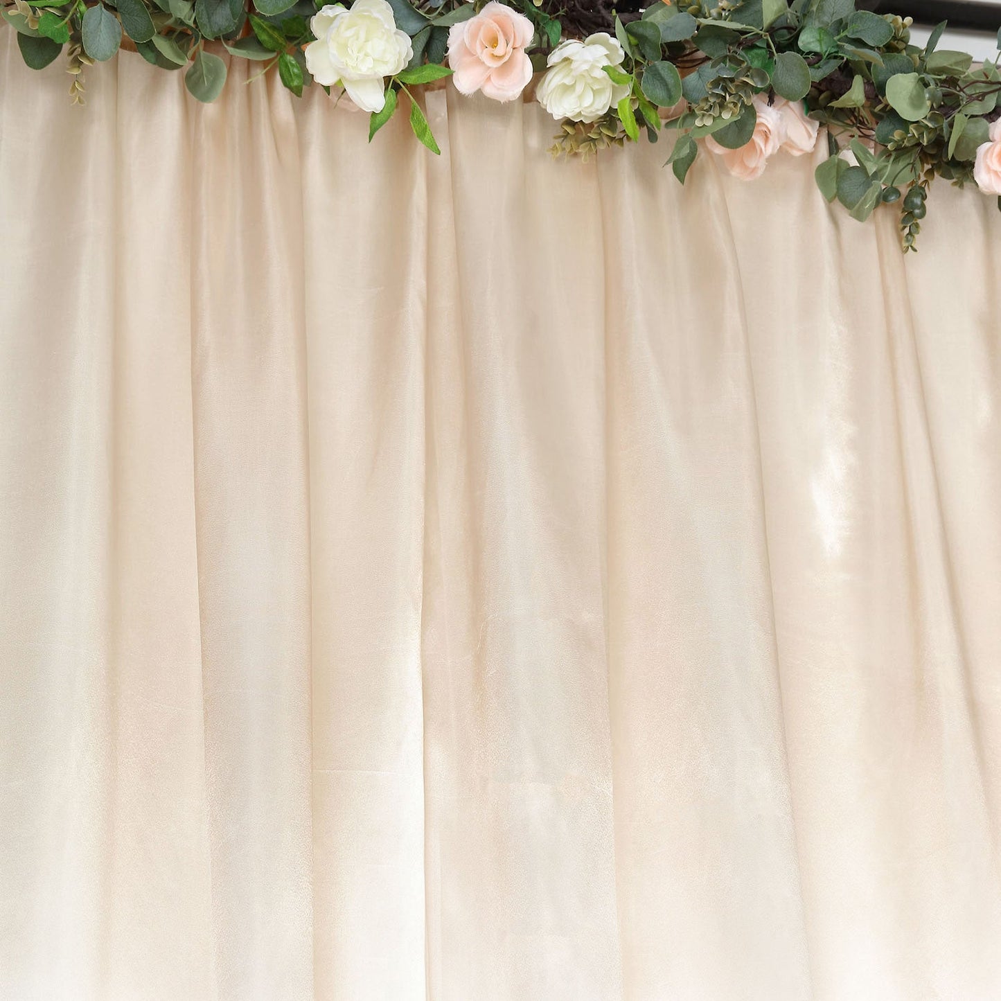 Beige satin event curtain drapes backdrop panel with floral accents.