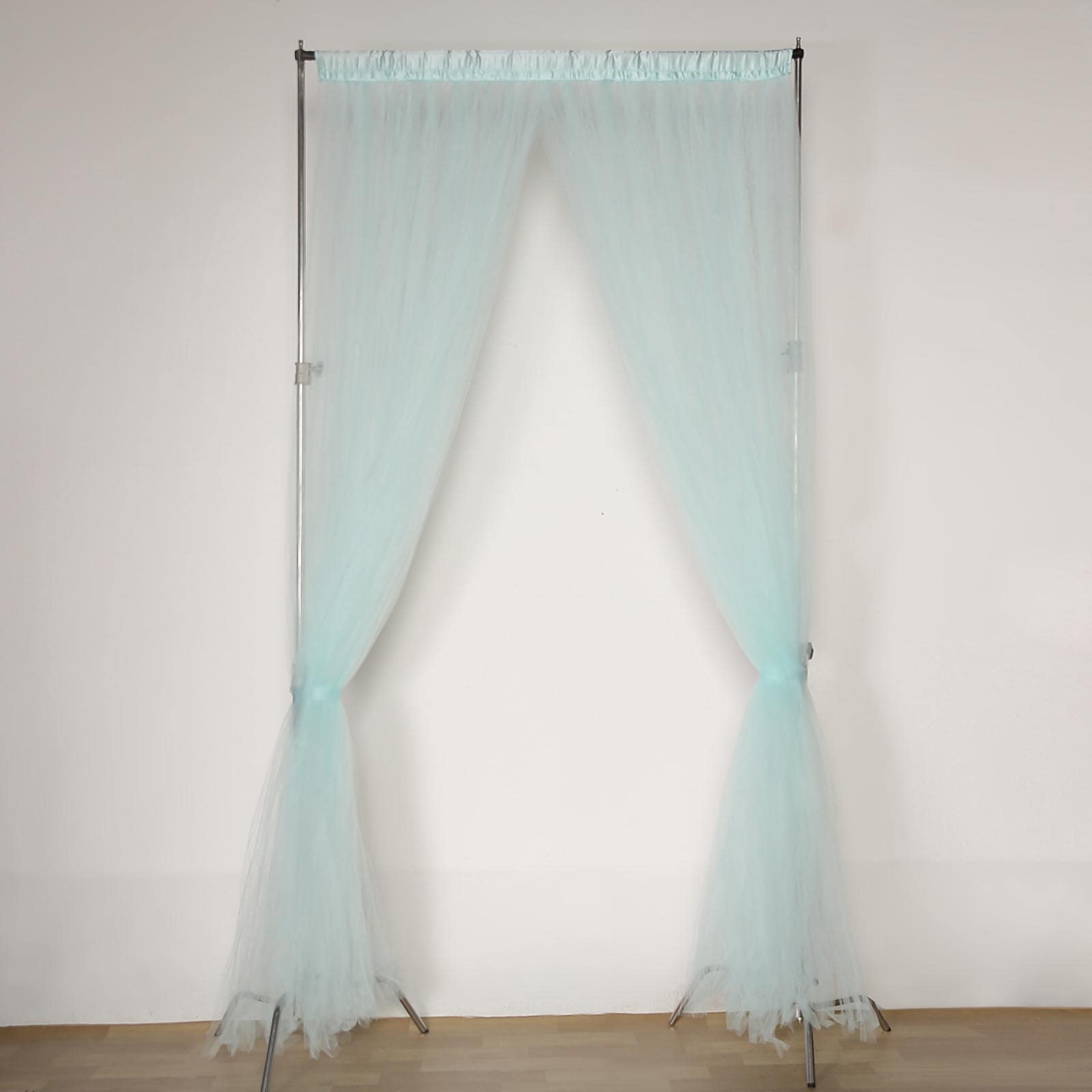Light blue sheer tulle event curtain drapes with satin header.