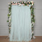 Light blue sheer tulle event curtain drapes with floral accents.