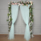 Light blue sheer tulle event curtain drapes with floral decoration.