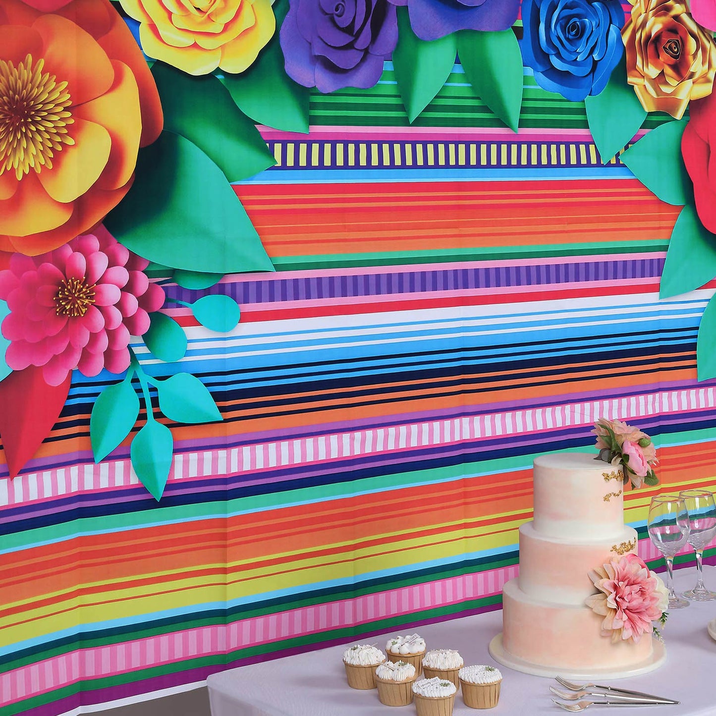 Colorful Cinco De Mayo fiesta backdrop with multi-color stripes and paper flowers.