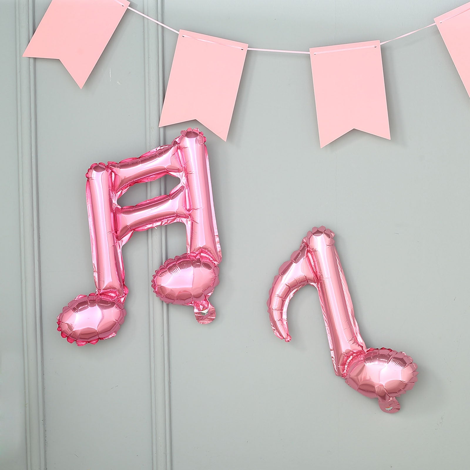 Rose gold music note mylar foil balloons hanging on a wall.