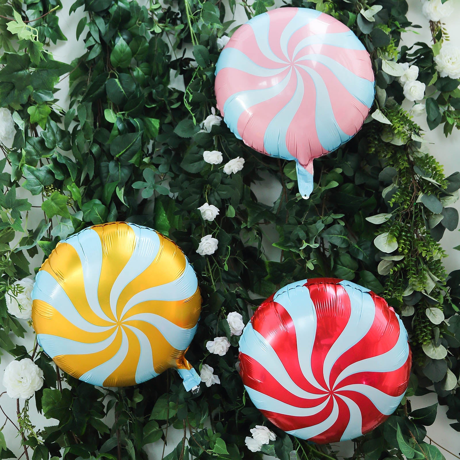 Candy striped swirl print mylar foil balloons in pink, gold, and red.