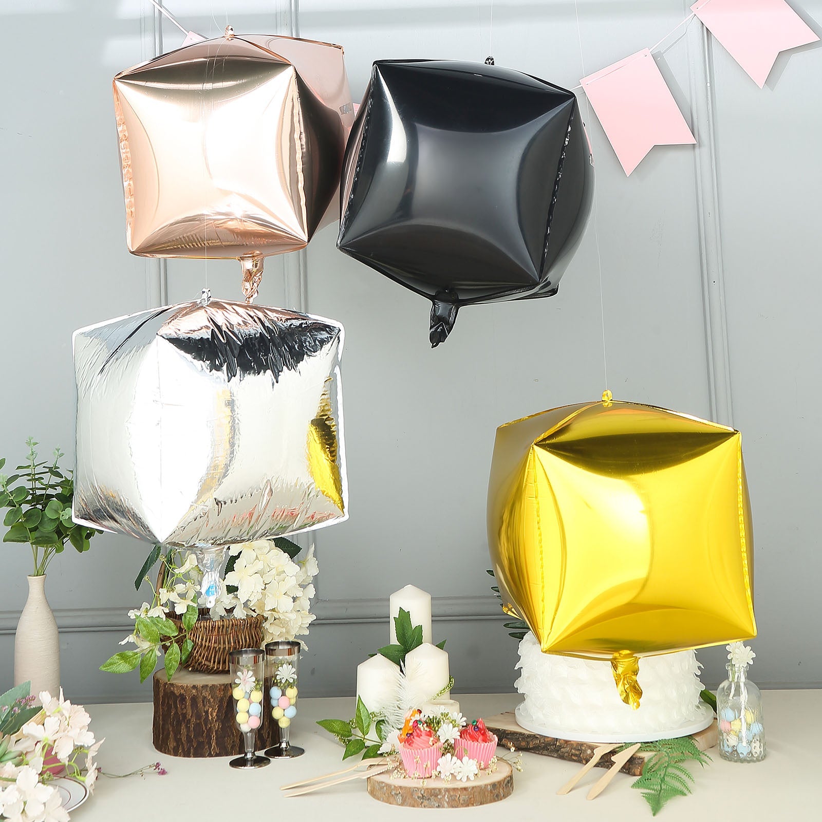 Rose gold cube-shaped mylar foil helium balloons.
