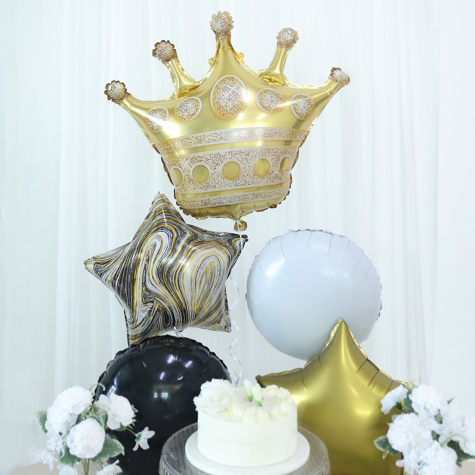 Gold and black marble foil balloon bouquet with star, round, and crown shapes.
