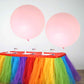 Large pastel blush balloons on a colorful table setting.
