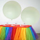 Large pastel mint balloons on a colorful table setting.